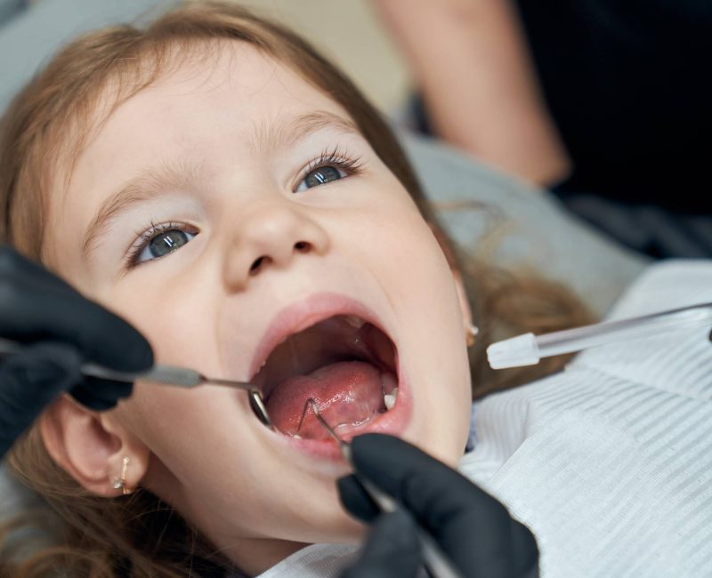 dentist-examining-condition-teeth-little-patient (1)